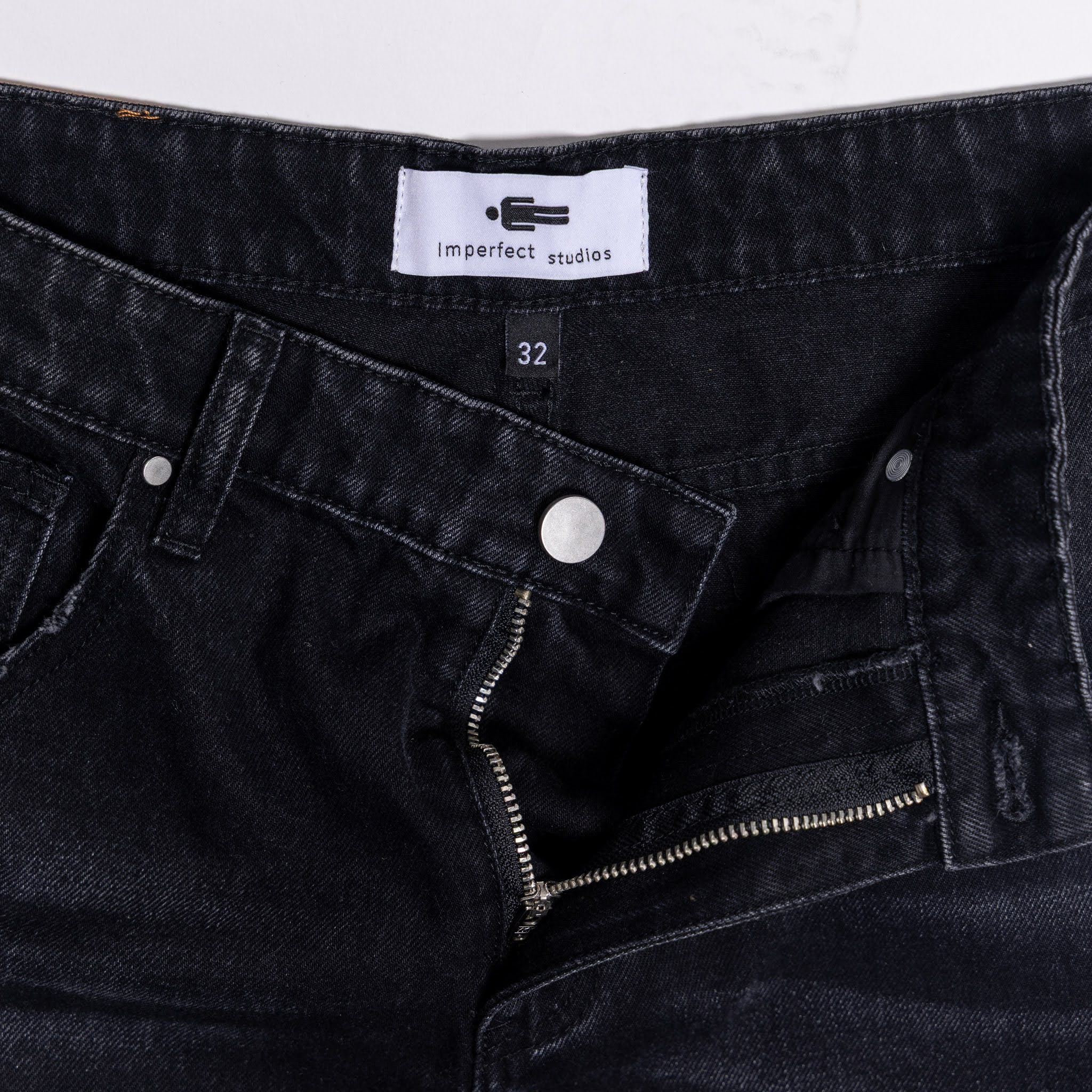 Black denim jeans with a visible brand label