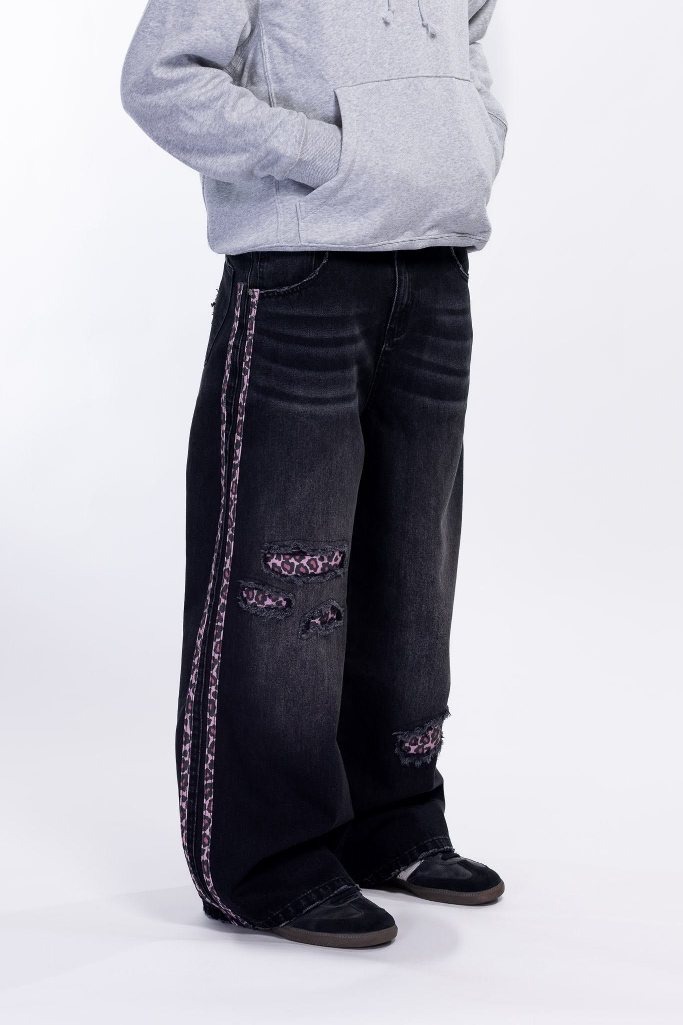Black jeans with pink leopard accents on a white background