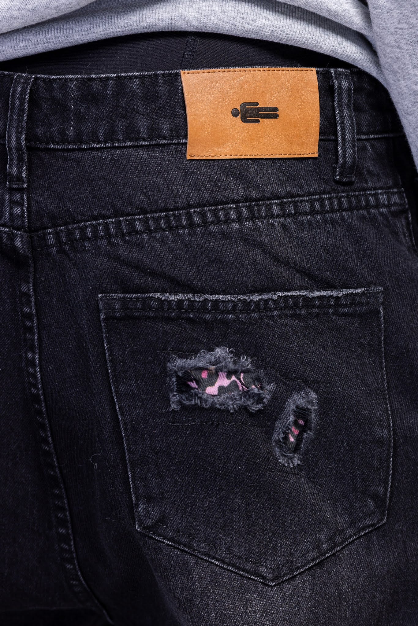 Black jeans with pink leopard patch on the pocket and a leather patch