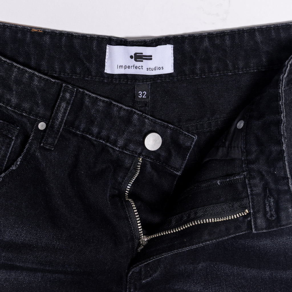 Black denim jeans with a visible brand label 
