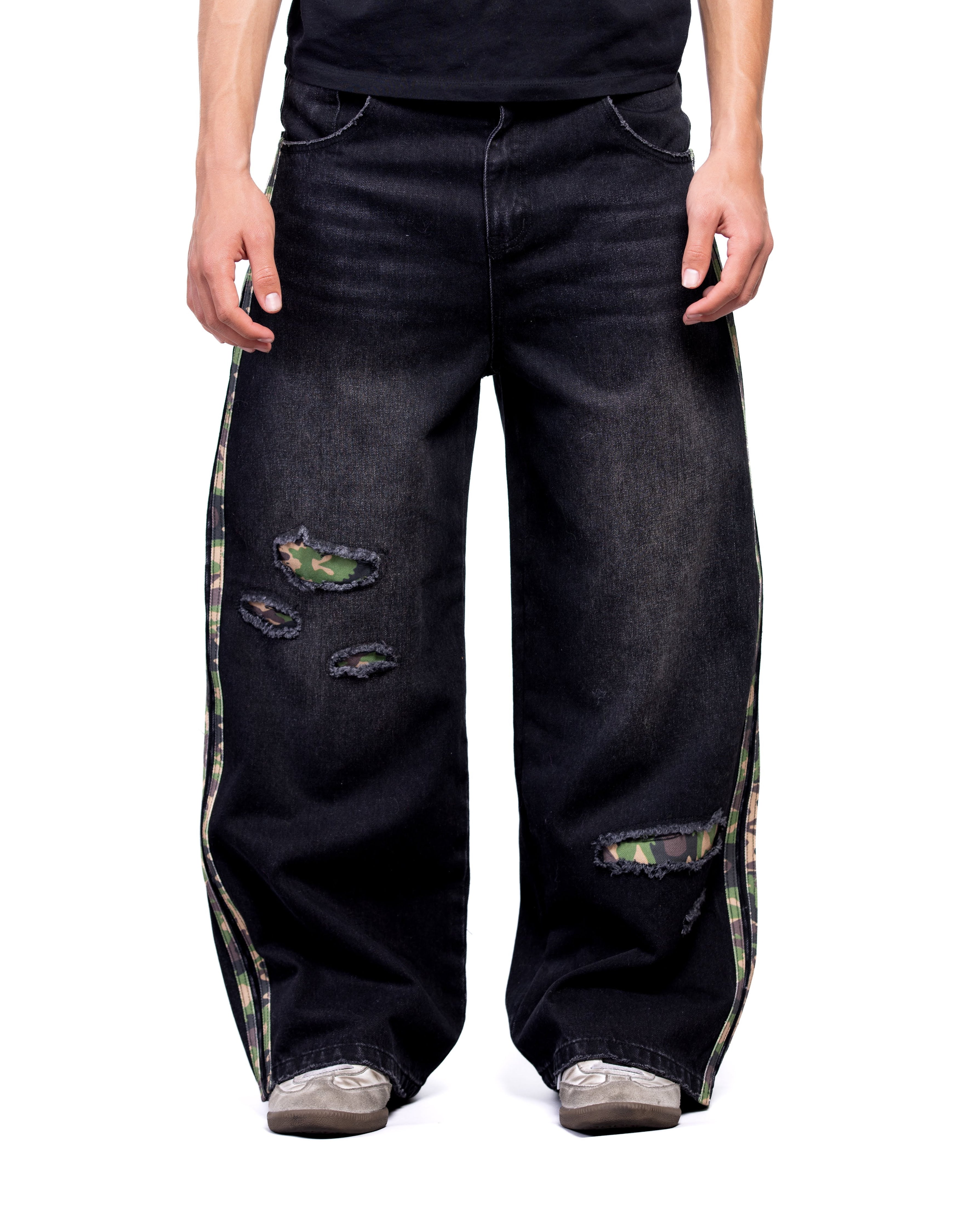 Black distressed jeans with camouflage patches on a white background