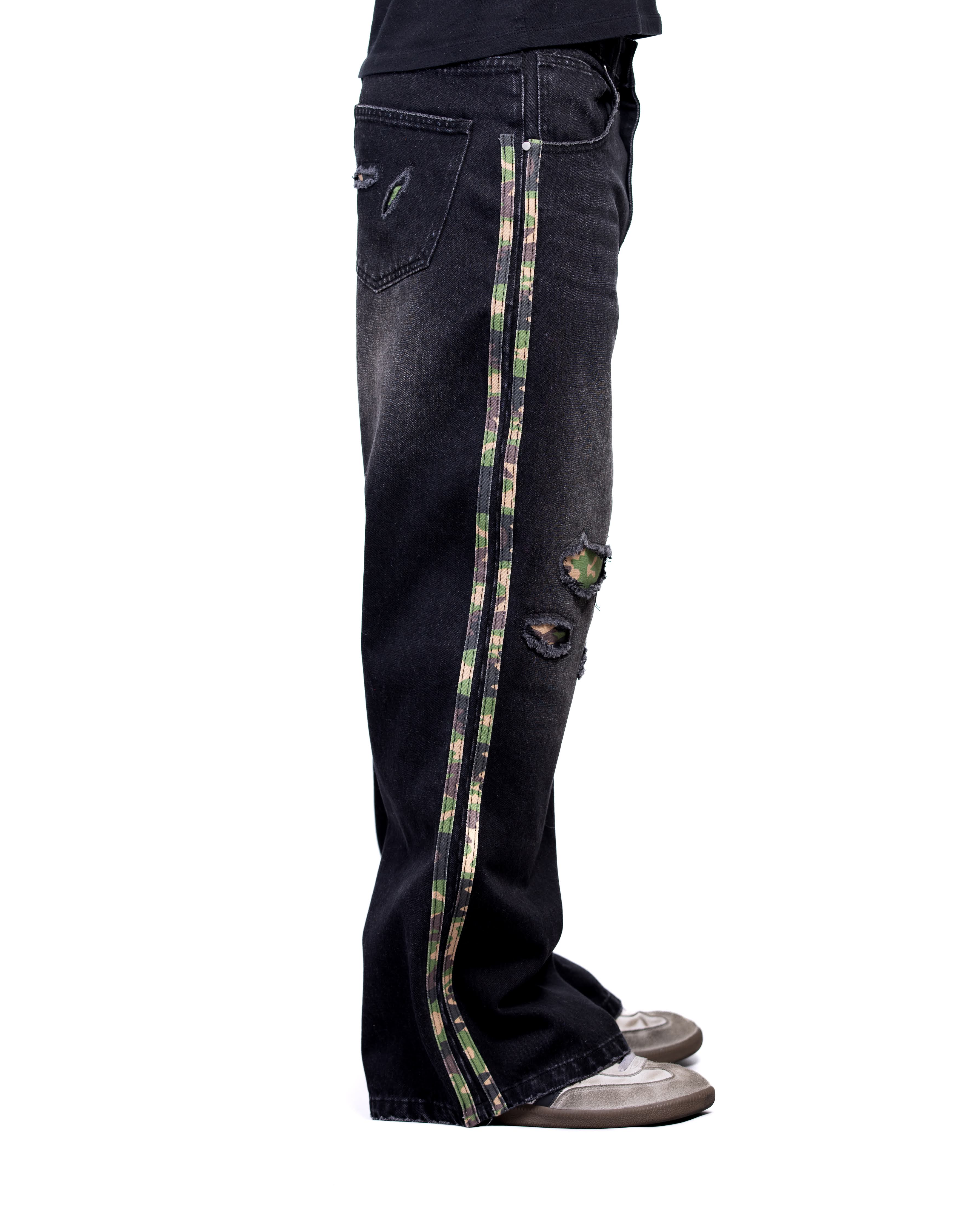 Black jeans with camouflage side strip worn by a person on a white background