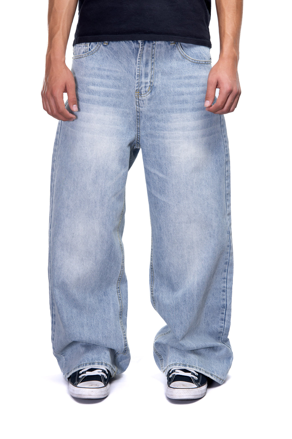 Person wearing light blue jeans and black shoes on a white background