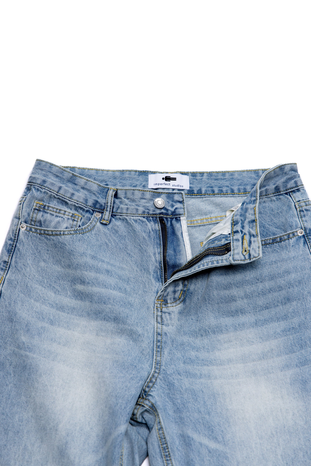 Close-up of a folded pair of blue jeans with a brand label on a white background