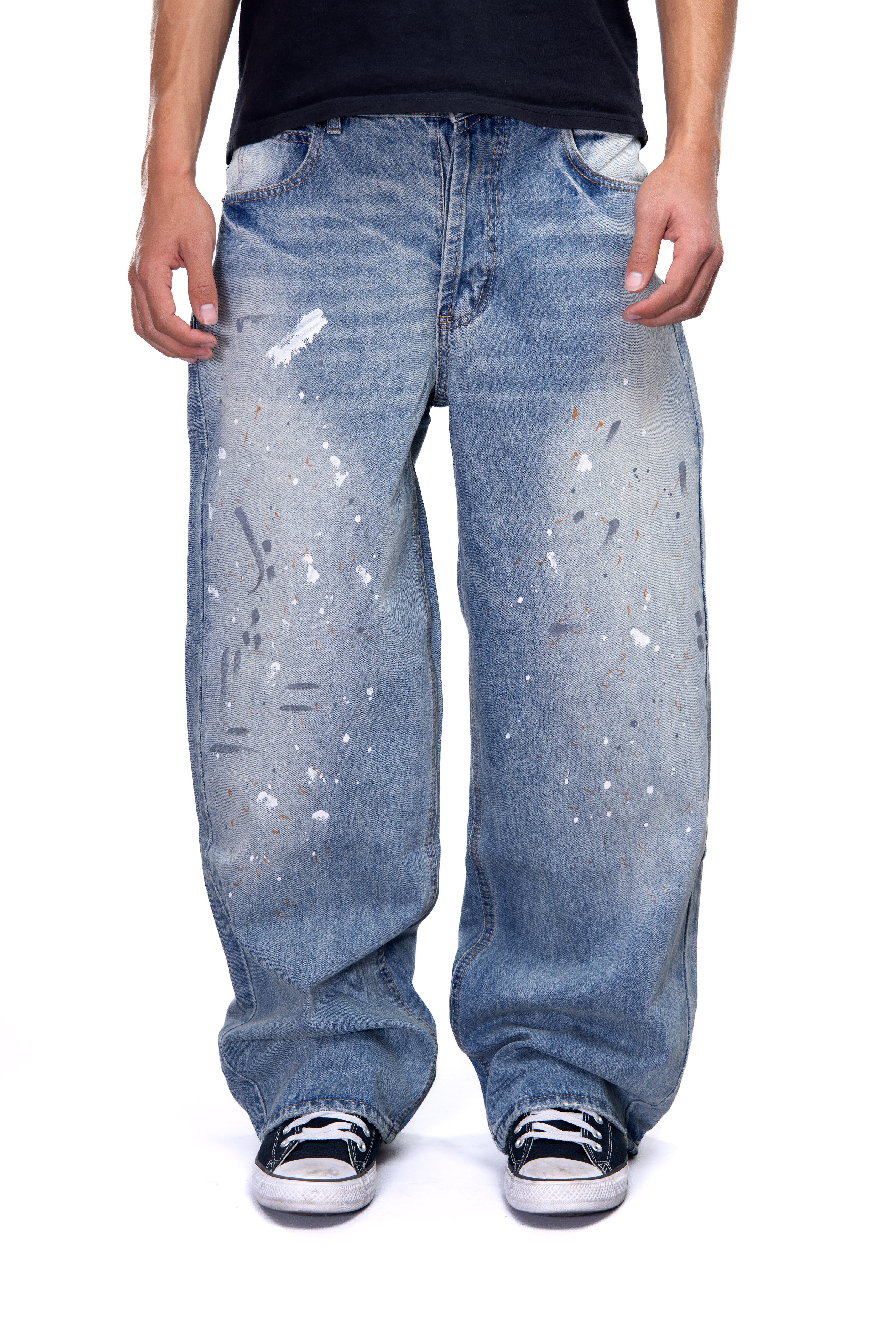 Person wearing light blue jeans with white paint splashes on a white background