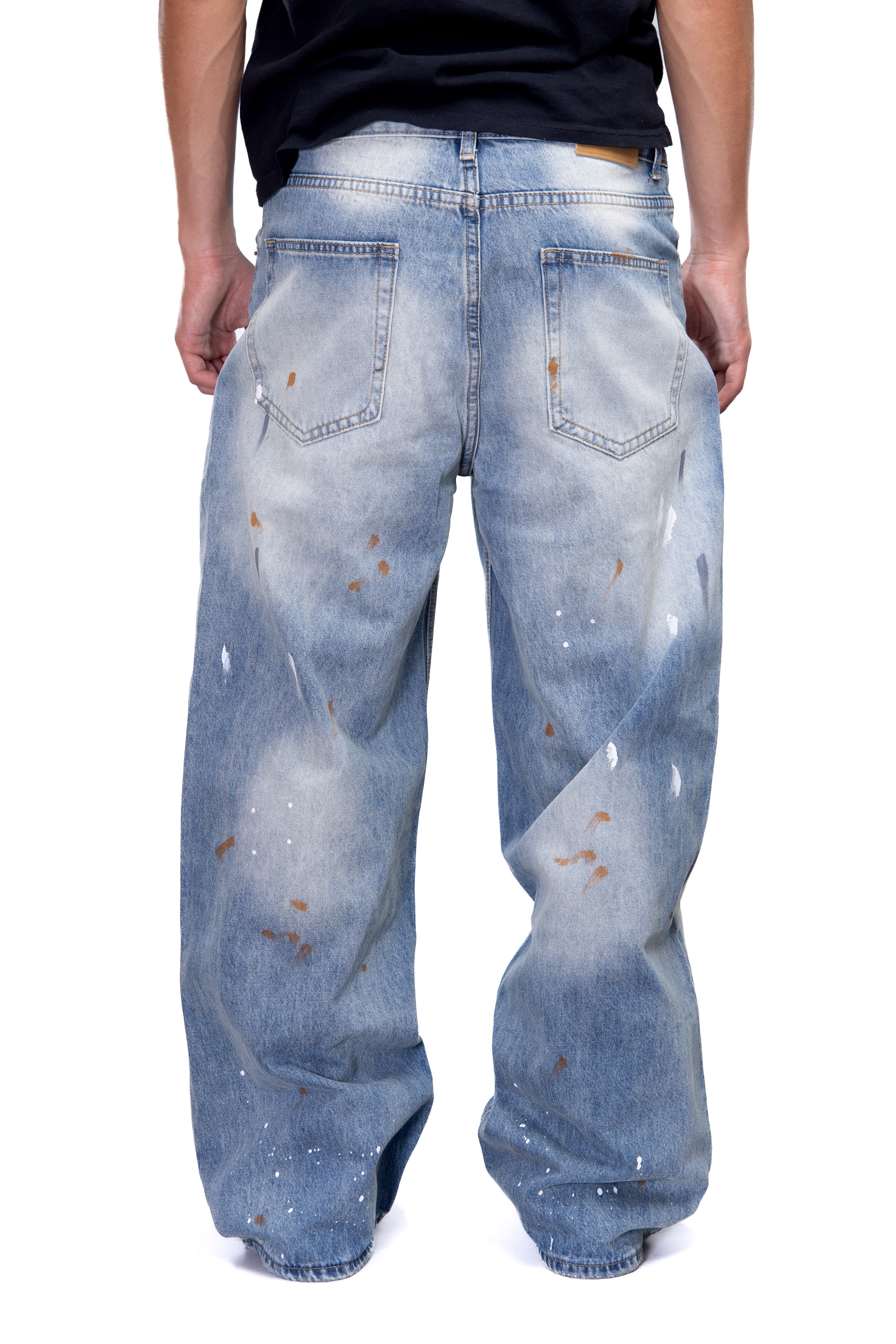 Blue distressed jeans worn by a person on a white background