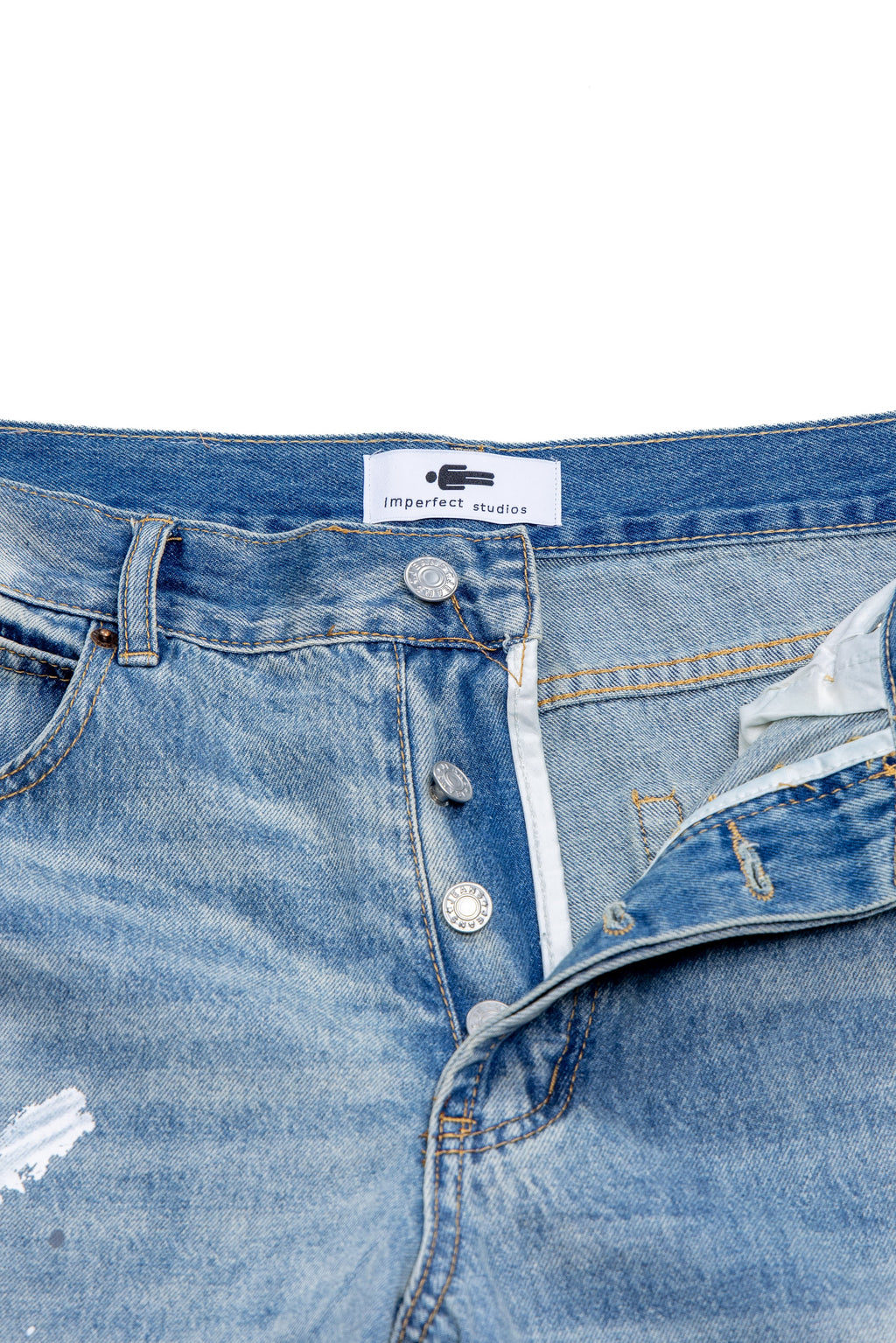 Close-up of a blue denim jeans with a brand label on a white background